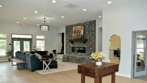 A spacious living area with a fireplace, sofas, a coffee table, and a view of the outdoors. - Landing | Stunning 2BD, Pool, Clubhouse (Ooltewah)