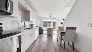 A modern kitchen with a black countertop, white cabinets, and a built-in microwave. - Landing | Incredible 1BD, Clubhouse (Austin)