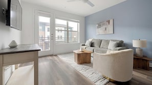 A modern living room with a sofa, a coffee table, a lamp, and a painting on the wall. - Landing | Stunning 1BD, Clubhouse (Austin)
