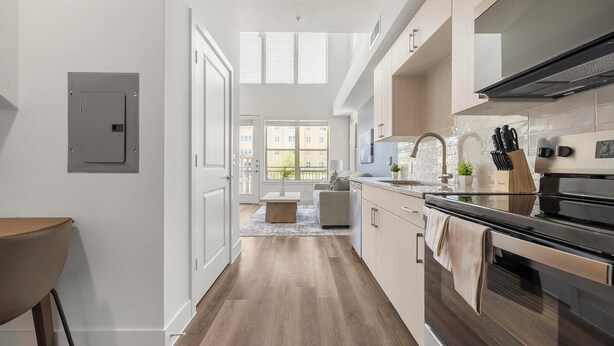 A modern kitchen with a built-in oven, stainless steel appliances, and a window overlooking a cityscape. - Landing | Chic 1BD, Clubhouse (Austin)