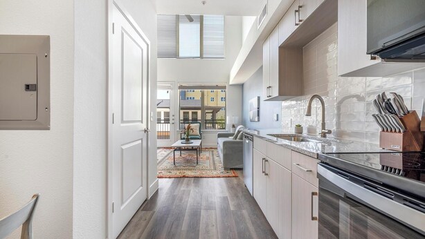 Una cucina moderna con forno integrato, lavello in acciaio inossidabile e finestra con vista su un balcone.
