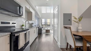 A modern kitchen with a built-in oven, a microwave, and a sink. - Landing | Stylish 1BD, Clubhouse (Austin)