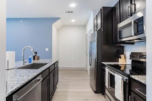 Eine moderne Küche mit Granit Arbeitsplatten, Edelstahlgeräten und einer blauen Akzentwand.