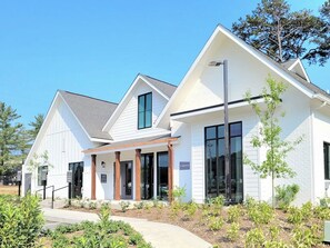A modern building with a covered entrance, large windows, and a landscaped garden area. - Landing | Spectacular 2BD, Gym (Knoxville)