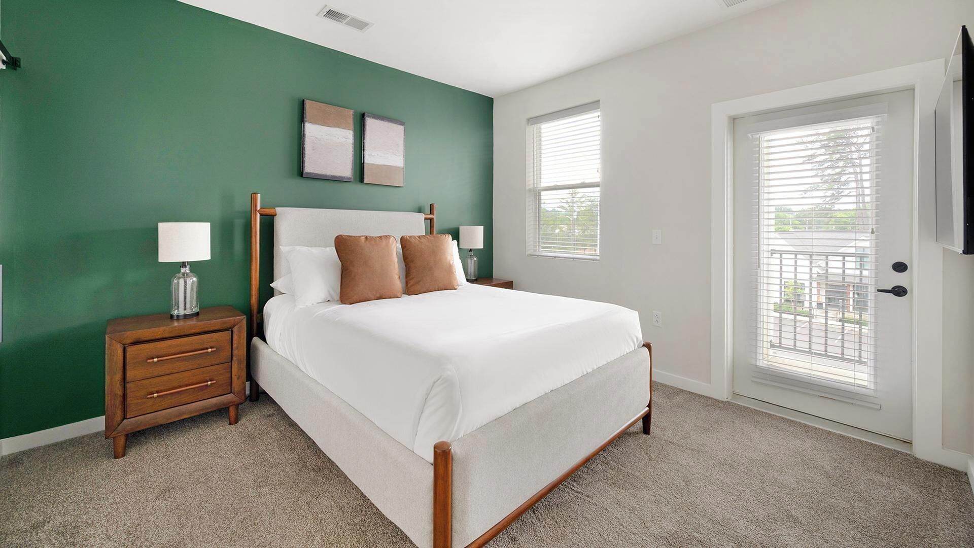A bedroom with a bed, nightstands, a dresser, a window, and a door.