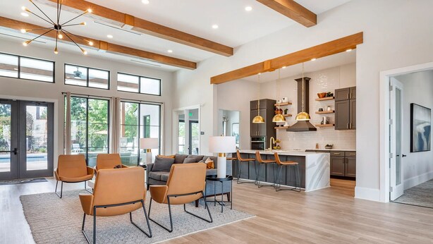 Amplia sala de estar con comedor, cocina equipada con electrodomésticos modernos y ventanas grandes que permiten la entrada de luz natural.