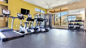 Ein Fitnessstudio mit Laufbändern, Crosstrainern und Gewichten.