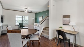Ein modernes Wohnzimmer mit Essbereich, einer Treppe und Blick ins Freie.