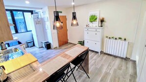 A modern kitchen with a wooden island, pendant lights, a white cabinet, and a radiator. - Room-cozy Guest Room in Modern Madrid Fl (Madrid)