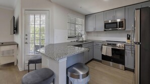 Eine moderne Küche mit Granit Arbeitsplatten, Edelstahlgeräten und einem eingebauten Ofen.