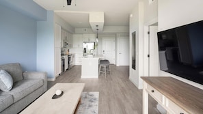 Ein modernes Wohnzimmer mit grauem Sofa, Couchtisch und TV-Schrank.