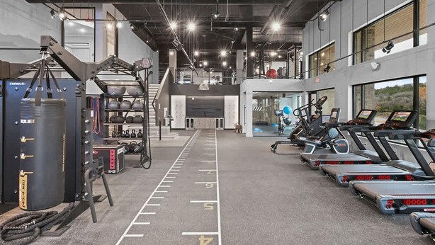 Ein Fitnessstudio mit Laufbändern, Kraftgeräten und einem Schlagring.