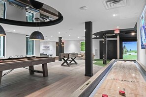 A modern indoor pool area with a pool table, a foosball table, and a large screen. - Landing | Spectacular 2BD in Cool Springs (Franklin)