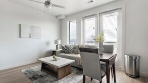 Ein modernes Wohnzimmer mit Sofa, Couchtisch und Essbereich.