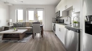 Ein modernes Apartment mit Wohnzimmer, Essbereich und Küche.