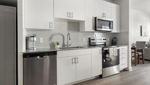 Una cocina moderna equipada con lavavajillas, estufa, microondas y cafetera.