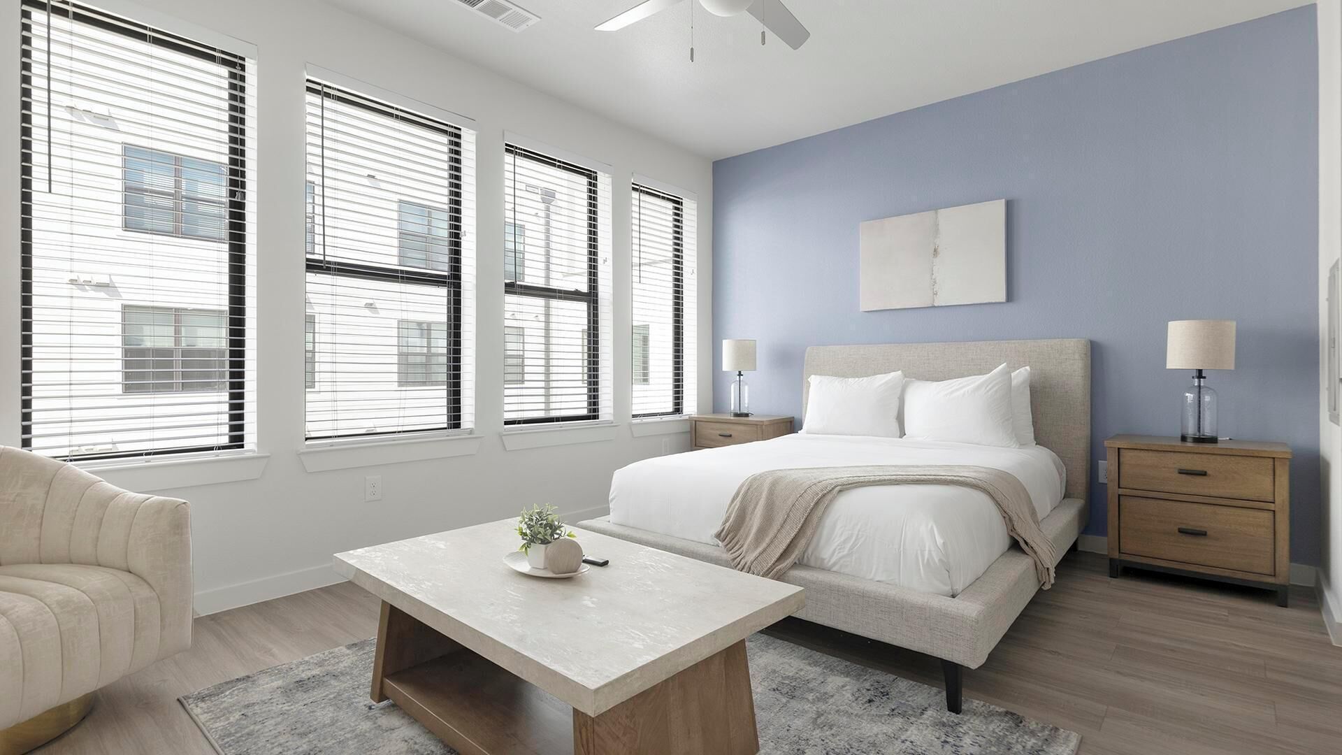 A bedroom with a bed, bedside tables, a chair, and a desk.