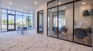 Un intérieur moderne avec de grandes fenêtres, un espace d’accueil et des coins salon.