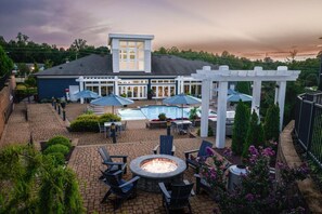A rooftop patio with a fire pit, outdoor seating, a pool, and a covered area with umbrellas. - Landing | Chic 1BD, Gym, Pool (Manassas Park)