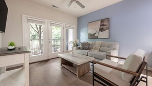 A modern living room with a sofa, coffee table, and a TV mounted on the wall.