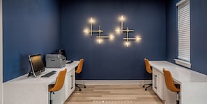 Ein zeitgemäßer Arbeitsbereich mit einer dunkelblauen Wand, einem weißen Schreibtisch und zwei Stühlen.
