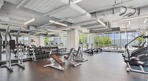 Ein Fitnessstudio mit Cardiogeräten, Kraftstationen und Kurzhanteln.