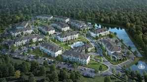 A residential area with multiple apartment buildings, a swimming pool, and a lake. - Landing | Stunning 1BD, Game Room (Lake Wales)