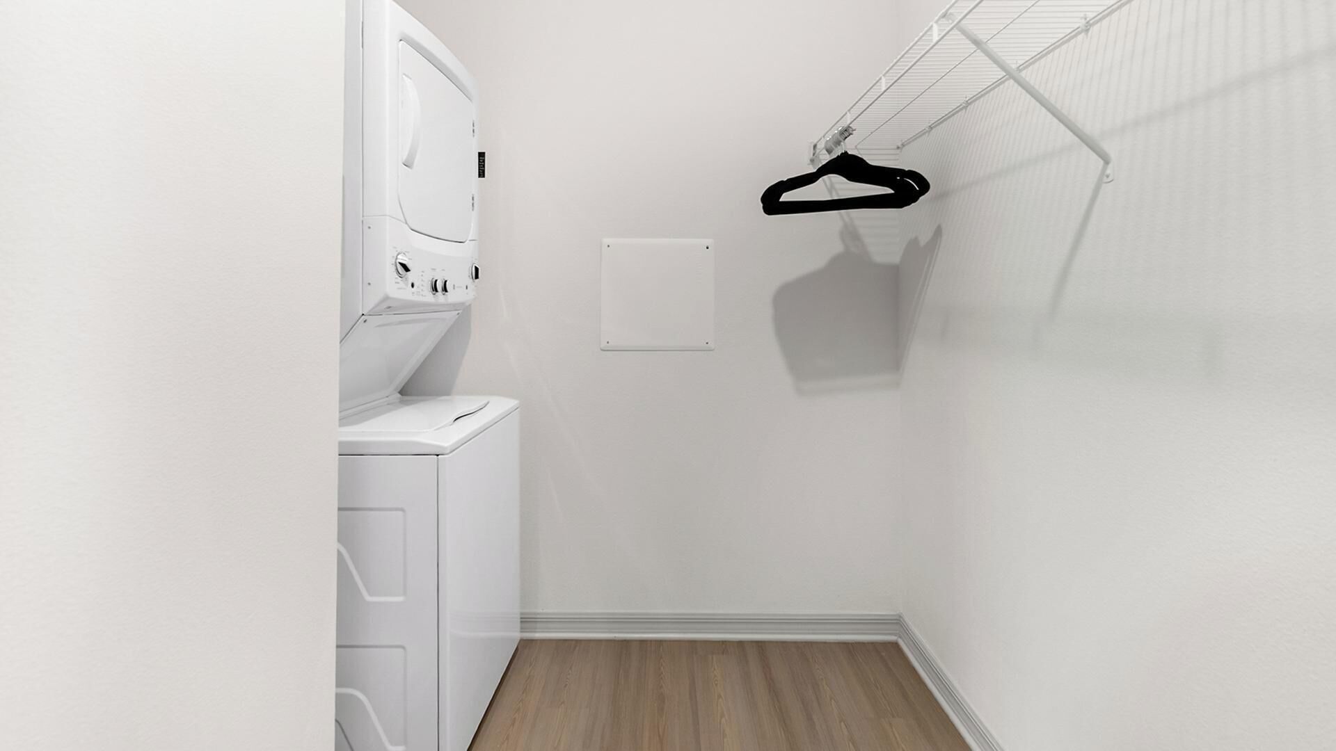 Un cuarto de lavado con lavadora, secadora y un tendedero.