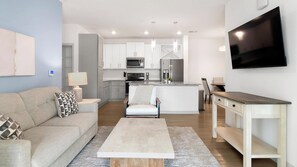 A modern apartment with a living room, kitchen, and dining area.