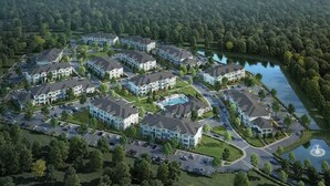 Un quartier résidentiel comprenant plusieurs immeubles d’appartements, une piscine et un lac.