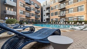 A poolside area with lounge chairs and a pool. - Landing | Stunning 2BD, Courtyard, Clubhouse (Dallas)
