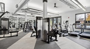 A gym with various exercise equipment, large windows, and a ceiling with ventilation ducts. - Landing | Beautiful 2BD, Gym, Clubhouse (Dallas)