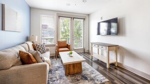 Ein modernes Wohnzimmer mit einer Couch, einem Couchtisch und einem Fernseher.