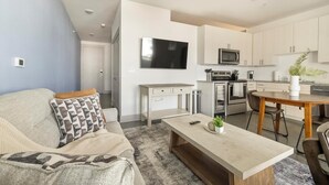 A modern apartment with a living room, kitchenette, and dining area. - Landing | Stunning Studio in Kessler Park (Dallas)