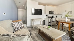 Eine moderne Wohnung mit Wohnzimmer, Küchenzeile und Essbereich.