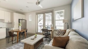 A modern living room with a sofa, coffee table, and dining area. - Landing | Stunning Studio in Kessler Park (Dallas)