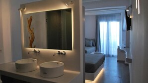 Une salle de bain moderne avec deux vasques rondes, un grand miroir et un élément décoratif en bois.
