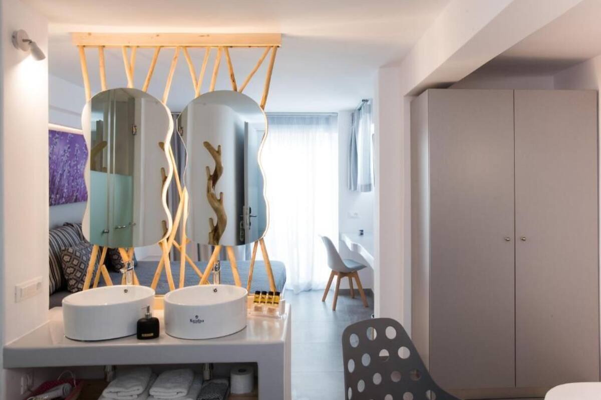 A modern bathroom with two sinks, a mirror, and a wooden structure above the mirror.