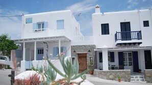 Un bâtiment blanc doté d’un balcon et d’une enseigne sur laquelle on peut lire « Hôtel ».