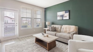 A modern living room with a sofa, a coffee table, and a lamp.