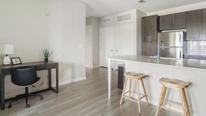 Eine moderne Küche mit einem Edelstahl-Kühlschrank, Holzschränken und einer weißen Arbeitsplatte.