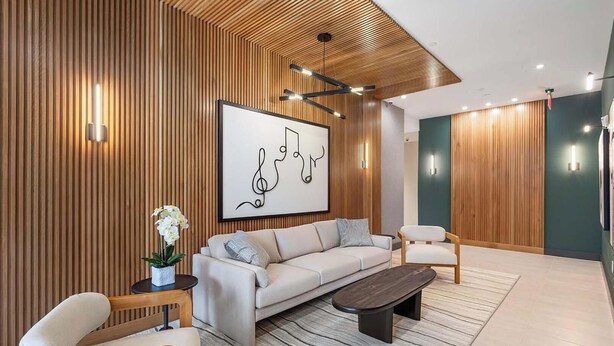 Un salon moderne comprenant un canapé, des fauteuils, une table basse et une œuvre d’art accrochée au mur.