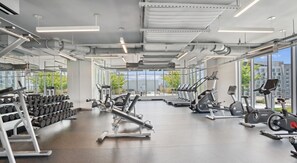 A gym with cardio machines, dumbbells, and weightlifting equipment. - Landing | Beautiful 1BD, Gym (Washington)