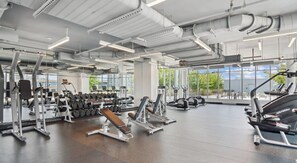 Ein Fitnessstudio mit Cardiogeräten, Kraftstationen und Kurzhanteln.