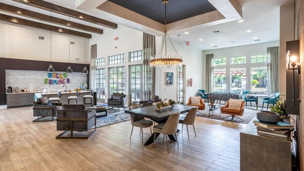A spacious living area with a dining table, sofas, and a large window offering a view of the outdoors. - Landing | Beautiful 1BD in Copperfield (Cypress)