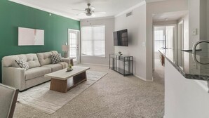 A living room with a sofa, coffee table, and TV. - Landing | Beautiful 1BD in Copperfield (Cypress)