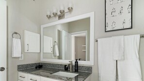 A bathroom with a large mirror, two sinks, a towel rack, and a framed artwork on the wall. - Landing | Incredible 2BD in Copperfield (Cypress)