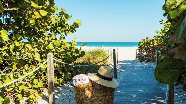 A beach path leading to a hotel named 'TROUVAULT' with a sign indicating it's in Miami Beach. - Hotel Trouvail | King | Euro-Miami Charm, Heated Pool, Art & Nightlife (Miami Beach)