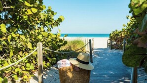 A beach path leading to a hotel named 'TROUVAULT' with a sign indicating it's in Miami Beach. - Hotel Trouvail | 2 Queen | Art Deco Charm, Beach Days, Euro-Miami Vibe | 2 Units (Miami Beach)