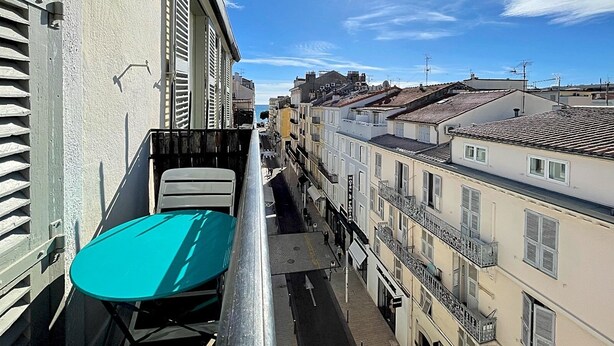 A narrow urban street with buildings on both sides, a clear sky, and the sun shining. - Viva Riviera Apartment with balcony near the sea (Cannes)